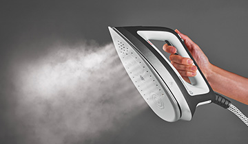 Das Bild zeigt wie der kraftvolle Dampf der Polti Vaporella Instant aus der Bügelsohle austritt