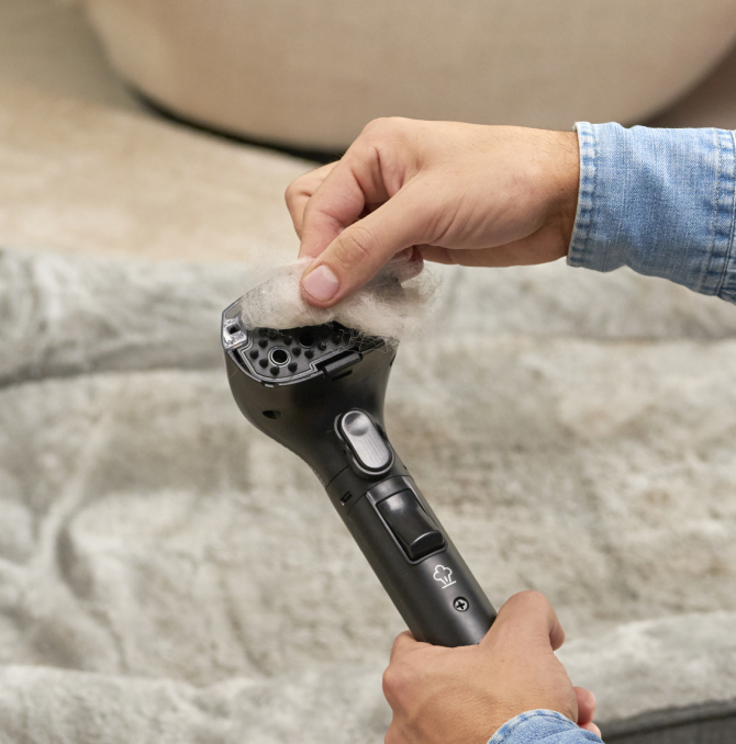 a person estracting hair from the spot cleaner gun