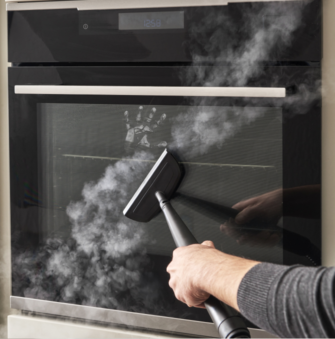 a steam cleaner cleaning a oven mirror