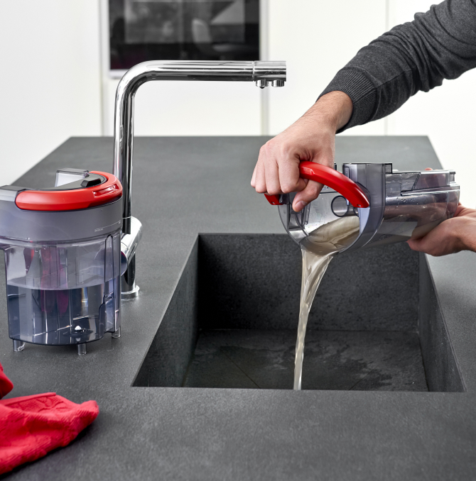 a person cleaning the dirty water tank in a sink