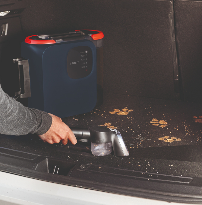 eine Person, die den Autolagerraum reinigt