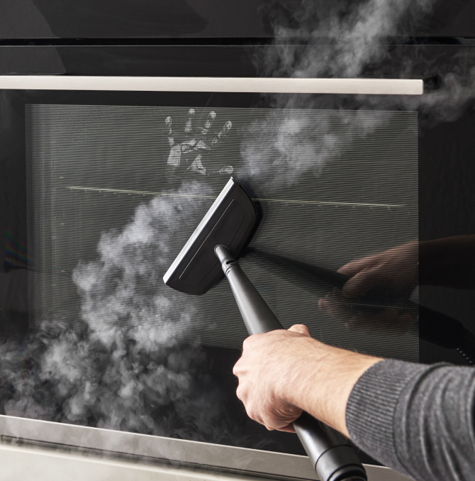 eine Person, die einen Ofenspiegel reinigt