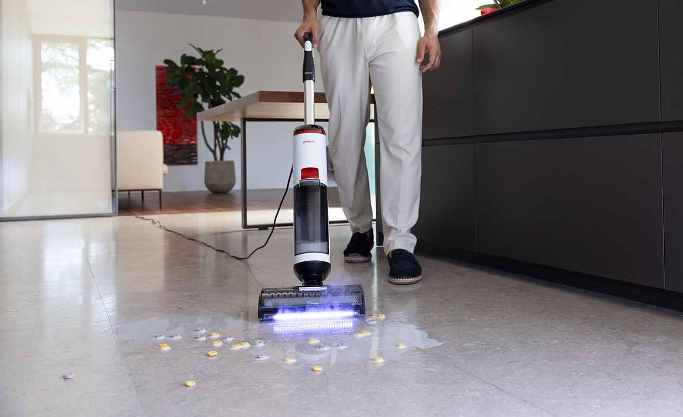 Ein Mann, der einen Marmorboden mit Polti Rollysteam reinigt